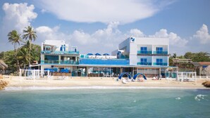 A beachfront hotel with multiple floors, balconies, and a pool area. - Hotel Poblado Coveñas (Coveñas)
