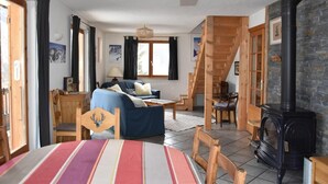 Un salon chaleureux avec un canapé, une table à manger et un escalier menant à l’étage supérieur.