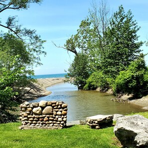 A stone structure near a river with lush greenery and a clear sky. - Steps from the beach,  Lakeview with Hot Tub (Dunkirk)