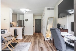 A modern living space with a kitchen, dining area, and a large mirror.