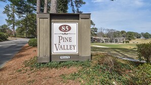 A sign for Pine Valley, marked as private property, with a golf course in the background.