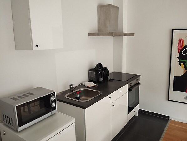 A compact kitchen with a microwave, coffee maker, and a small oven. - Quiet and central incl. parking lot (Bad Honnef)