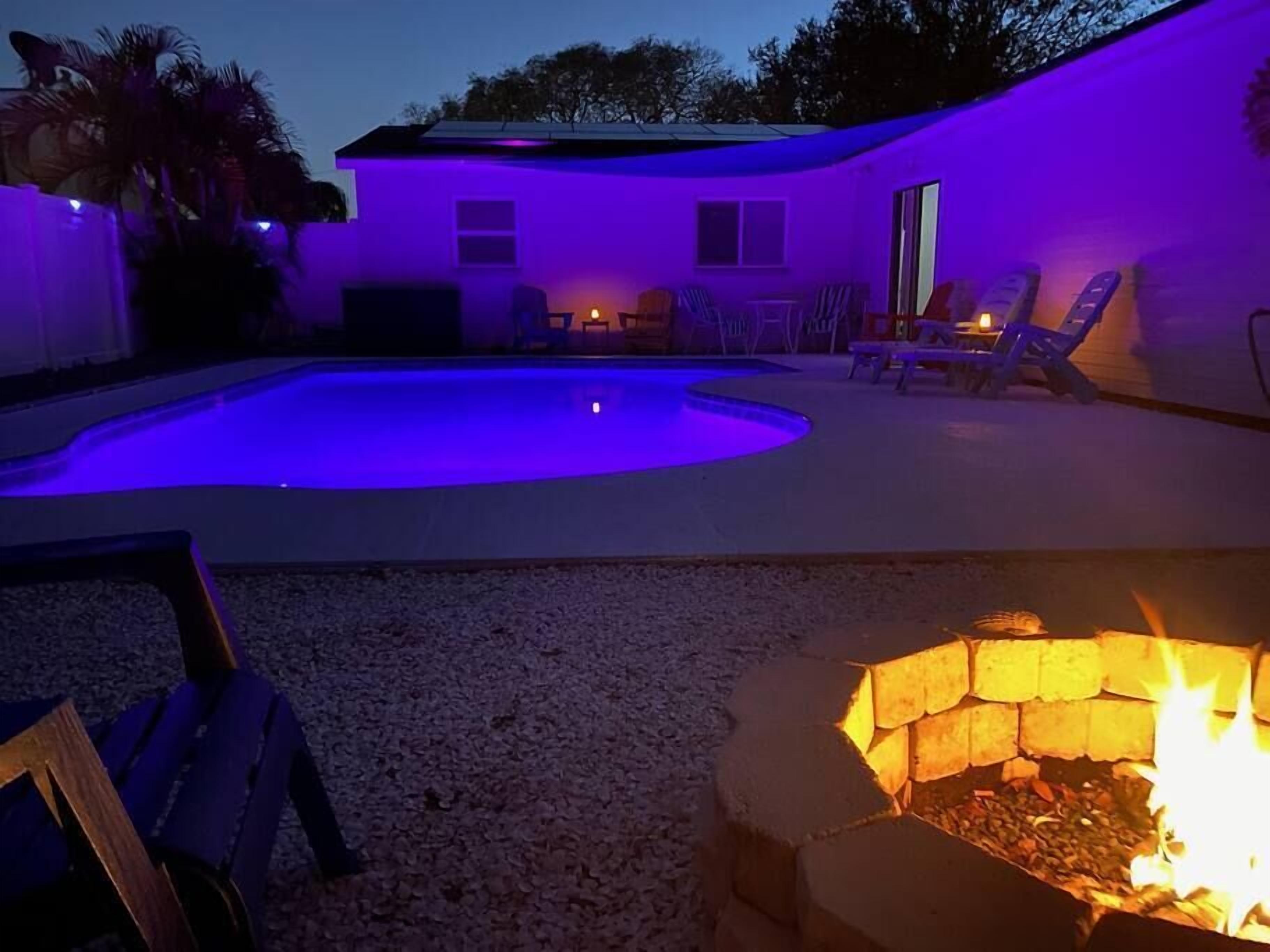 Ein Garten mit Swimmingpool, Feuerstelle und Gartenmöbeln.