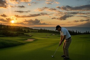 Ein Golfplatz mit Sonnenuntergangsblick, einem Gewässer und einem bewaldeten Gebiet.