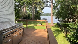 A deck with a barbecue grill, overlooking a lake with trees and a dock. - Lake Murray Gem - Lakefront Dock (Chapin)