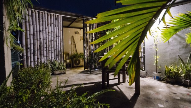 An outdoor area with bamboo fencing, potted plants, and a concrete floor. - Quiet yet located in the heart of the city....! (Guwahati)