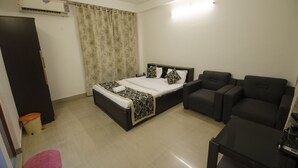 A bedroom with a bed, a sofa, a coffee table, and a ceiling fan. - Quiet yet located in the heart of the city....! (Guwahati)