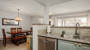 Una cocina con lavavajillas, encimera de granito y pileta.