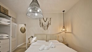 A bedroom with a large bed, a bedside table with a lamp, a wardrobe, and a hanging light fixture. - Stylish Apartment at Pagrati (Vironas)