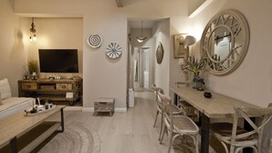 A living room with a TV, wooden furniture, and decorative wall art. - Stylish Apartment at Pagrati (Vironas)