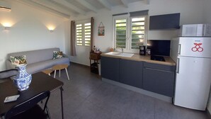 Una cocina compacta con horno empotrado, cafetera y microondas.