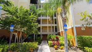 A hotel entrance with a pathway leading to a building with multiple balconies. - 9.1 miles from Disney World, Sleeps 8-10, heated pool, hot tub, private balcony (Kissimmee)