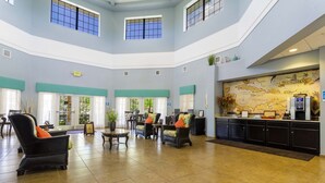 A spacious lobby with a high ceiling, multiple seating areas, a reception desk, and a large map on the wall. - 9.1 miles from Disney World, Sleeps 8-10, heated pool, hot tub, private balcony (Kissimmee)