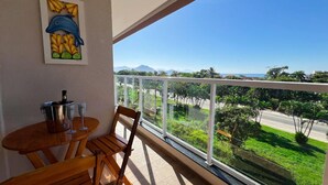 Ein Balkon mit Tisch, Stühlen, einer Flasche und zwei Gläsern.