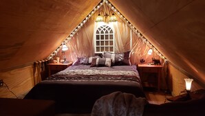 Un dormitorio tipo buhardilla acogedor con una cama, dos mesitas de noche y una ventana.