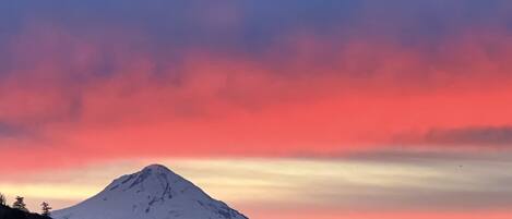 A snow-capped mountain under a colorful sky.