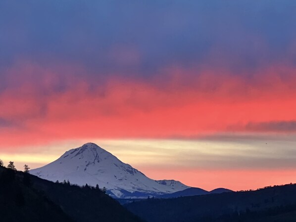 Une montagne enneigée sous un ciel aux couleurs vives.