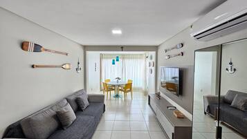 A modern living room with a sofa, TV, and decorative items.