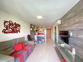 Una sala de estar moderna con un sofá, una zona de comedor y una cocina al fondo.