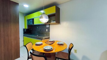 Una cocina compacta con comedor, microondas y una lámpara colgante.