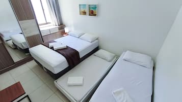 A hotel room with two beds, a desk, a mirror, and artwork on the wall.