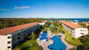 Um resort com piscina, vários edifícios e vista para o oceano.