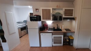 A compact kitchen with a refrigerator, microwave, toaster, and coffee maker. - Appartement de L'isard Bleu, Dans Résidence de Tourisme 3 Étoiles (Lourdes)