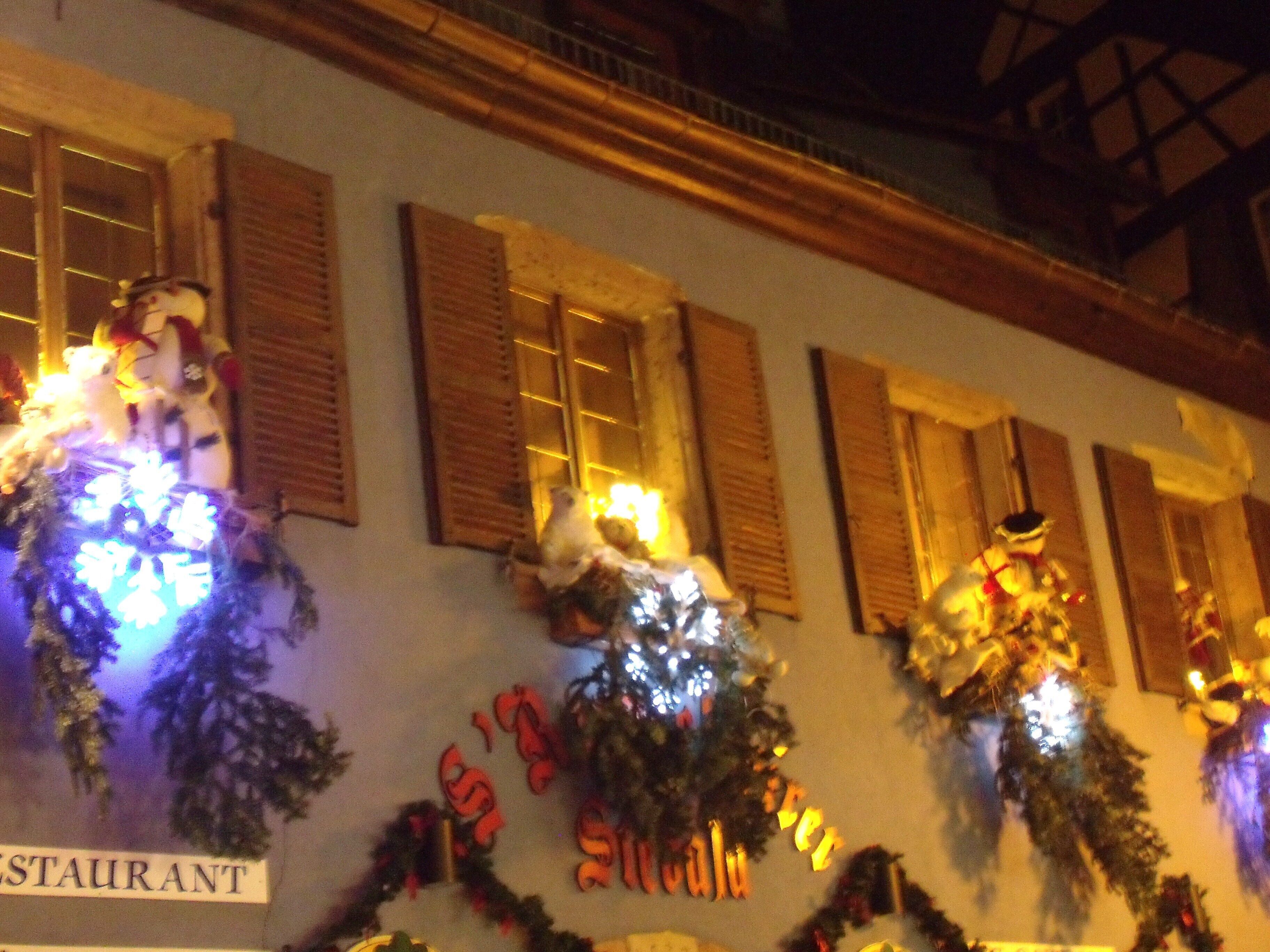 A building with multiple windows, some with shutters, and a sign that reads "RESTAURANT".