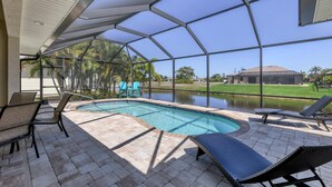 Una piscina cubierta al aire libre con sillones de descanso y vistas a una zona residencial.