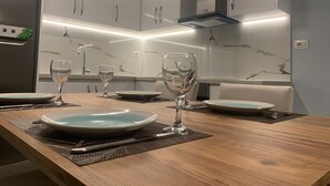 A modern kitchen with marble backsplash, built-in cabinets, and under-cabinet lighting.
