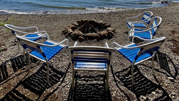 A beach with a fire pit and blue chairs arranged around it. - NEW Dock with large platform.  Bring the boat!  Lakefront Farmhouse.   (Romulus)