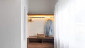 A narrow hallway with a wooden ceiling, a bench with baskets, and a hanging light fixture.