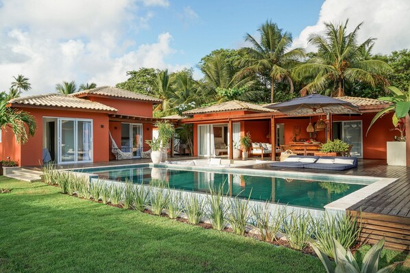 Un resort con piscina, mobiliario exterior y palmeras.