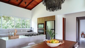 Una cocina moderna con una isla grande, encimera de madera y un bol de fruta.