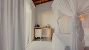 Een slaapkamer met een bed, een bureau en een kleine koelkast.
