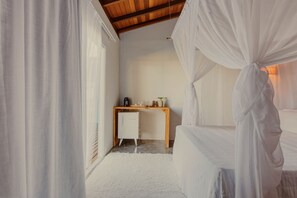 Une chambre avec un lit, un bureau et un petit réfrigérateur.