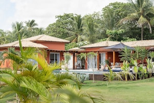 Un resort con due edifici, una piscina e vegetazione lussureggiante.