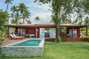 A modern house with a swimming pool, large glass windows, and a wooden deck. - Orixás Residence (Cairu)