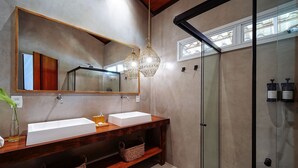 Un baño moderno con dos lavamanos, un espejo grande y una cabina de ducha de vidrio.