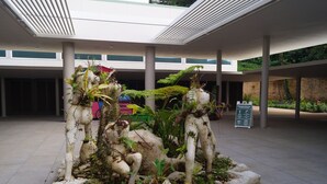 A modern building with a central garden featuring large rocks and plants. - Villa Teresa1, equipped with solar panels,water cistern, air conditioner, WiFi  (Carolina)