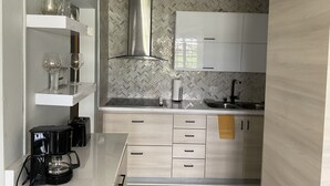 A modern kitchen with white cabinets, a stainless steel range hood, and a herringbone-patterned backsplash. - Villa Teresa1, equipped with solar panels,water cistern, air conditioner, WiFi  (Carolina)