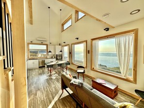 Una cocina amplia con ventanas grandes, una zona de comedor con banco y vistas al mar.