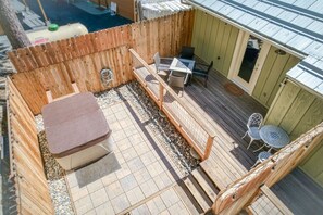 Eine Holzterrasse mit Tisch und Stühlen, eine kleine Sitzecke und eine überdachte Veranda.