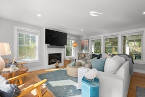 A living room with a fireplace, a television, and a sofa.