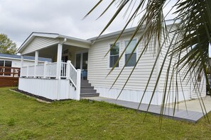 Une maison de plain-pied avec un porche et un escalier d’entrée.