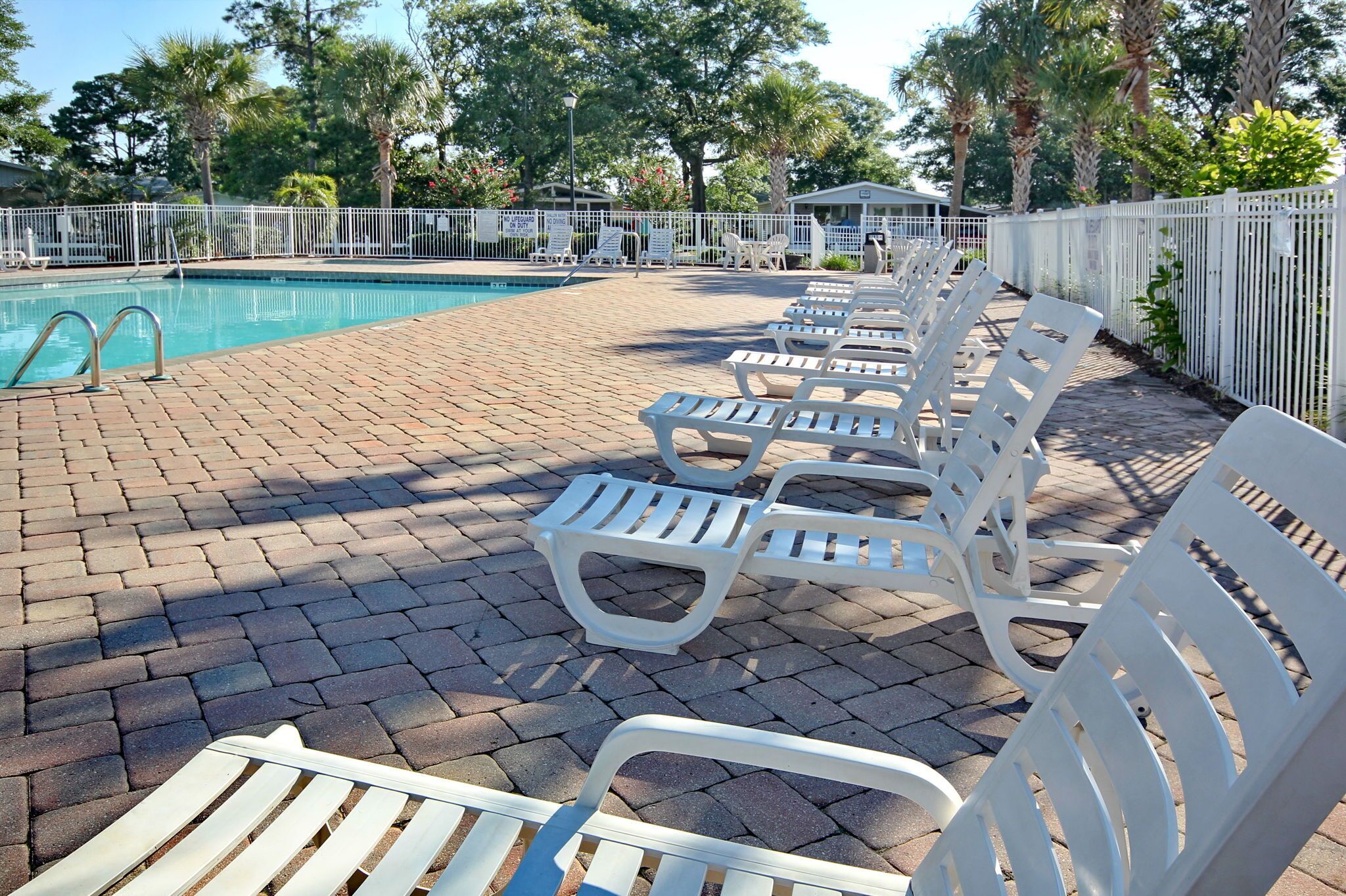 A poolside area with lounge chairs and a pool.