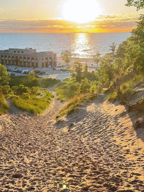 Una spiaggia con un parcheggio e un edificio con finestre ad arco.