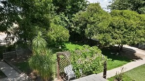A garden with a wooden pergola, a white chair, and a small pond with ducks. - 2 bedroom, 2 bath farmhouse (Blythe)