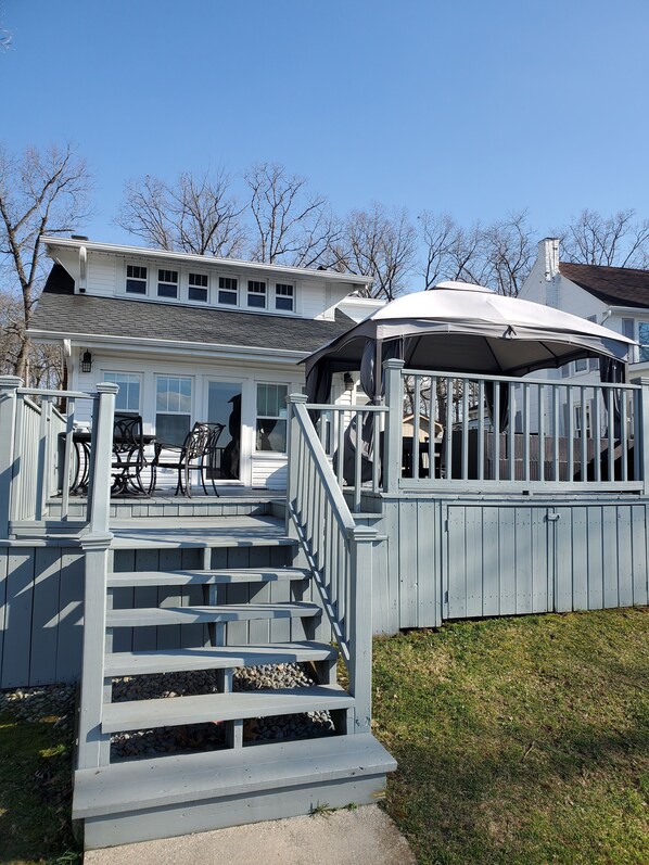 A two-story house with a covered porch and a staircase leading to the upper level.