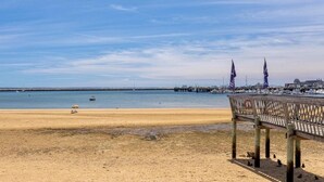 A beach with a wooden pier and a clear sky. - Spectacular Views in Center of Town and on the Beach! (Provincetown)